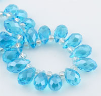 Perle de verre cristal, Goutte avec facettes et éclat. Dimension: +-14x8mm. Percée dans le sens de la largeur côté pointe. Couleur: Aigue Marine Code: D09215 --- Goutte avec facettes +-14x8mm. Aigue marine---