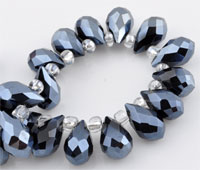 Perle de verre cristal, Goutte avec facettes et éclat. Dimension: +-14x8mm. Percée dans le sens de la largeur côté pointe. Couleur: Noir Jet Code: D09217 --- Goutte avec facettes +-14x8mm. Noir Jet---