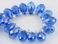 Perle de verre cristal, Goutte avec facettes et éclat. Dimension: +-14x8mm. Percée dans le sens de la largeur côté pointe. Couleur: Capri Blue Code: D09219 --- Goutte avec facettes +-14x8mm. Capri Blue---