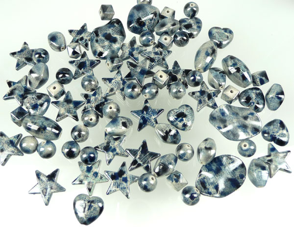 Mélange de perles de matière synthétique, décorées. Dimension: entre +- 10mm et 36mm. Contient +- 65 pièces. Couleur dominante: Gris-Bleu Code: D06059 --- Mélange synthétique +- 65 Pcs. Gris-Bleu---