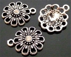 Pendentif, Breloque en matière métallique décoré et avec strass central. Forme de fleur. Dimension: +- 18x15mm. Couleur: Cristal Code: D08660 --- Breloque en metal avec strass. 18x15mm.---