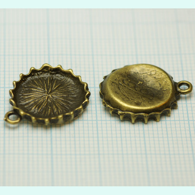 Pendentif, breloque de métal couleur bronze antique en forme de capsule. Inscription: Cocoa. Dimension: +- 21x16mm. Code: CAPS001 --- Mini Capsule Bronze 21x16---