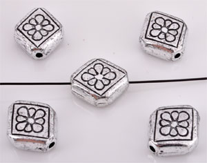 Perle en matière synthétique. Métal look. Carreau plat décoré avec fleur. Dimension: +-12x10x5mm. Couleur: Argent vieux. Code: D09062 --- Metal look. Carreau plat 12x10x5mm.---