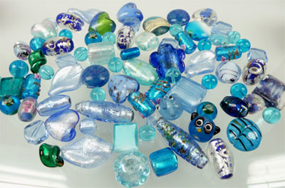 Mélange de perles en verre de +- 6mm. à 28mm. Couleur dominante: Bleu. +- 90 pièces par sac. Code: D02937 --- Melange verre 6-28mm. Bleu---